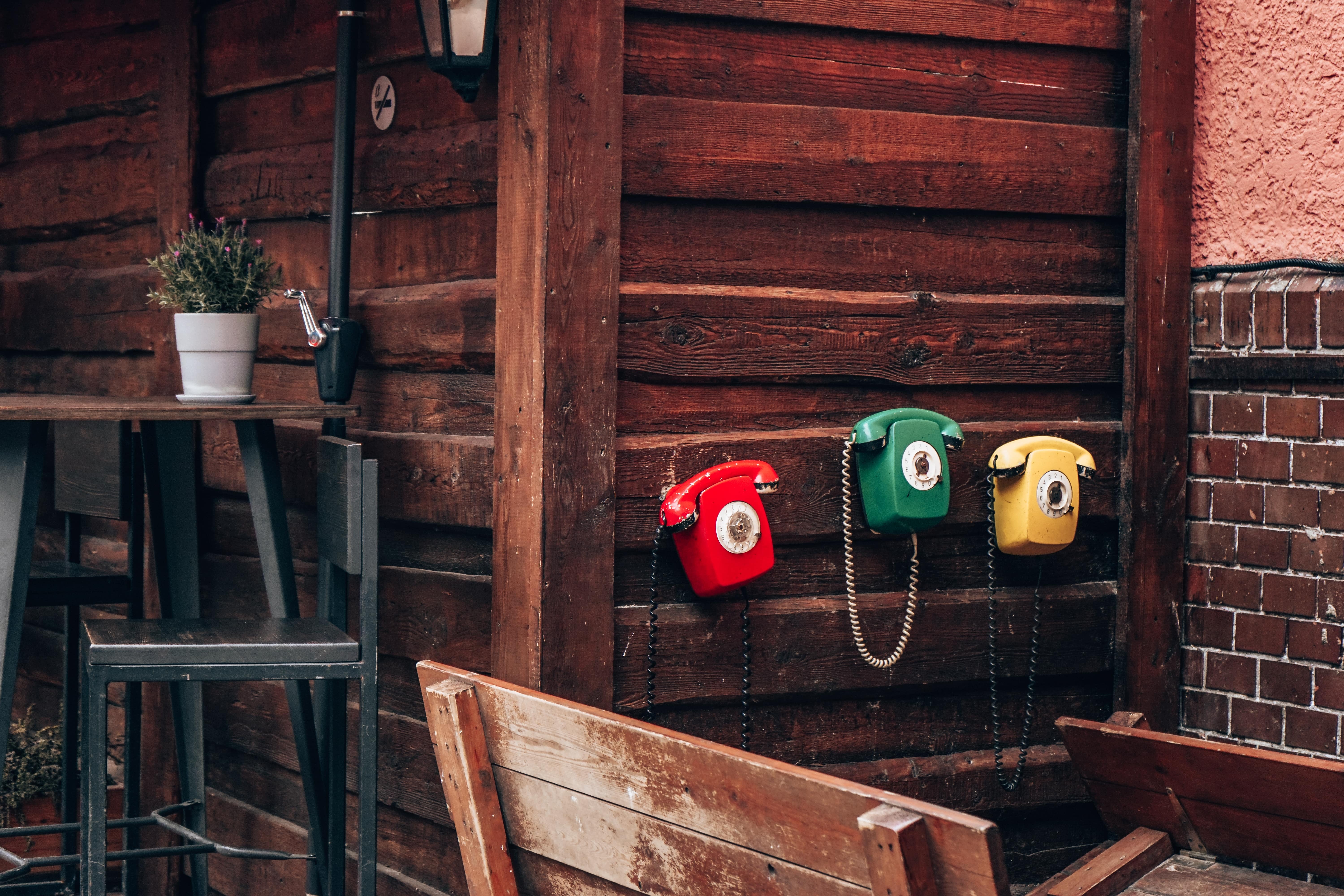 art-project-three-old-style-phones-on-a-wooden-wal-2021-10-12-18-41-50-utc-min